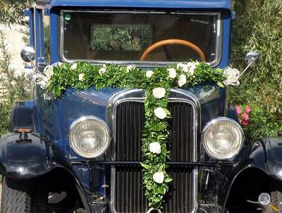 Festlich geschmückter Oldtimer als Hochzeitslimousine mit Blumendekoration