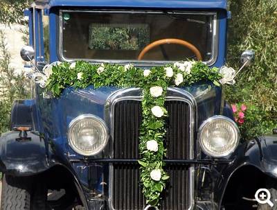 Festlich geschmückter Oldtimer als Hochzeitslimousine mit Blumendekoration